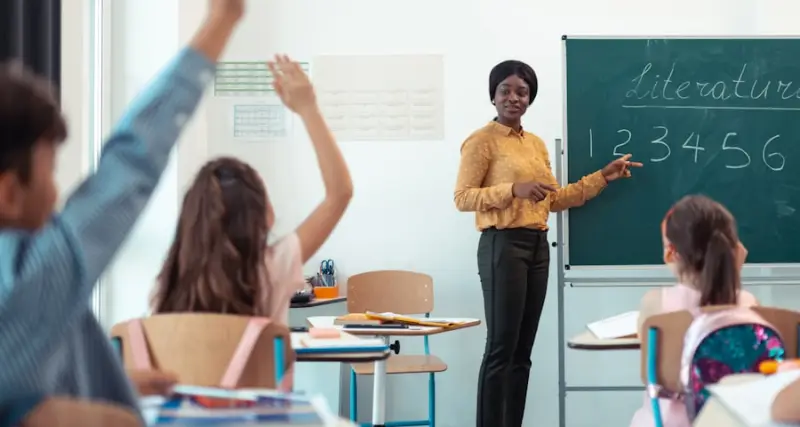 Teacher taking questions in a bright classroom